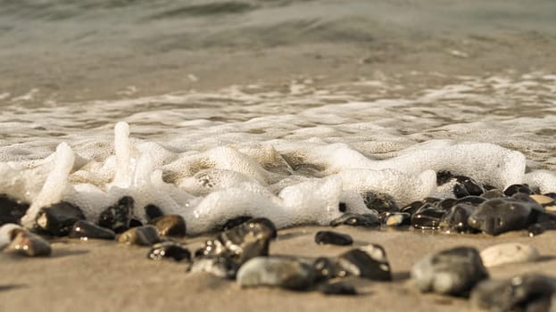 on the beach of the baltic sea with many flints. in addition waves which roll on the beach