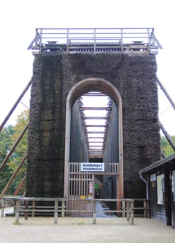 A graduation tower (occasionally referred to as a thorn house is a structure used in the production of salt which removes water from a saline solution by evaporation, increasing its concentration of mineral salts.Ein Gradierwerk (auch Leckwerk) ist eine Anlage zur Salzgewinnung. Sie besteht aus einem Holzgerüst, das mit Reisigbündeln (vorwiegend Schwarzdorn) verfüllt ist