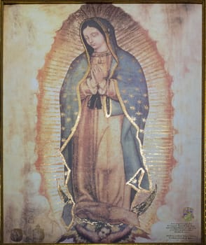 Caceres, Spain - Oct 26th, 2021: Our Lady of Guadalupe Painting, reprod. from Sagrado Ayate de Juan Diego. Church of San Juan, Caceres, Extremadura, Spain