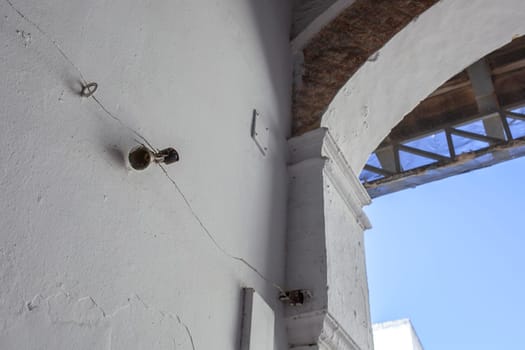 Mechanically operated doorbell on a torsion spring actuated by a wire. Bell nailed to whitewashed wall
