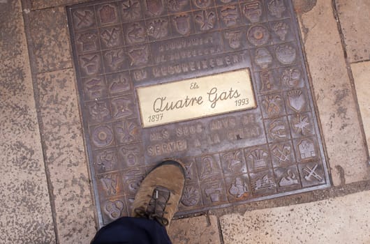 Barcelona, Spain - Dec 29th, 2019: Els Quatre Gats cafe. Winter visitor walking over ground plaque