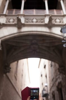 Tourist taking pictures to Bridge at Bisbe street, Barri Gotic, Barcelona. Spain