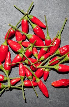 Black slate with piri-piri chili pepper. Studio shot with natural light. Wooden background