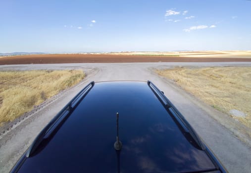 Driving off road by rural tracks. View from car roof