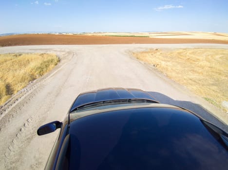 Driving off road by rural tracks. View from car roof