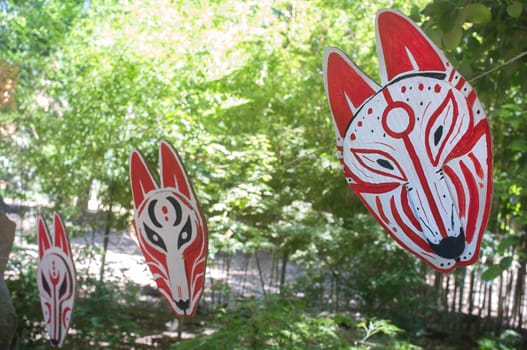 Carboard Kitsune mask hanging on rope. Japanesse culture craft workshop concept