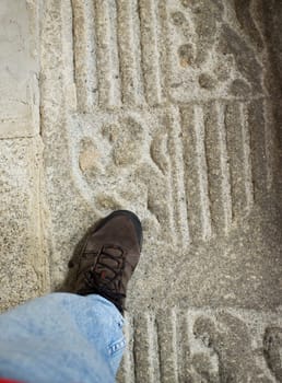 Caceres, Spain - Oct 26th, 2021: Walking over tomb slab on floor at Church of San Juan. Caceres, Extremadura, Spain