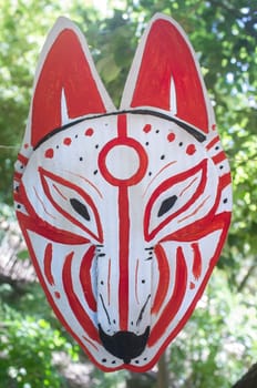 Carboard Kitsune mask hanging on rope. Japanesse culture craft workshop concept