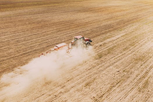 Aerial View. Tractor With Seed Drill Machine Sowing The Seeds For Crops In Spring Season. Beginning Of Agricultural Spring Season. Countryside Rural Field Landscape.