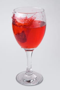 raspberry splashing into glass of wine red juice drink splash water drop on white background