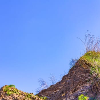 Excavated sand mountains and rubble piles quarry lake dredging pond lake with blue sky and landscape nature forest panorama view in Eggestedt Schwanewede Osterholz Lower Saxony Germany.