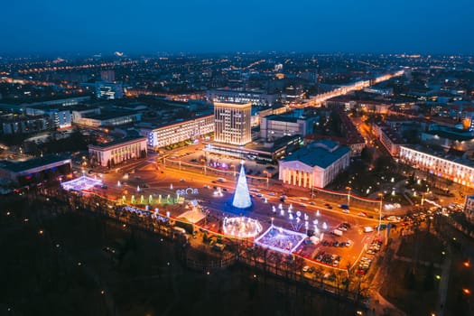 Gomel, Belarus. Main Christmas Tree And Festive Illumination On Lenin Square In Homel. New Year Celebration In Belarus. Aerial Night View.