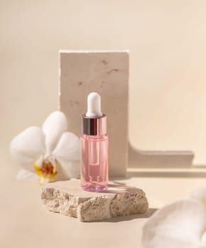 Dropper Bottle on stone near white orchid flowers on light yellow, close up, mockup. Skincare beauty product, essential oil or serum. Exotic cosmetics, pastel minimal composition..