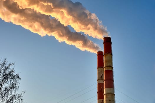 white smoke is coming out of the pipes in the blue sky. High quality photo