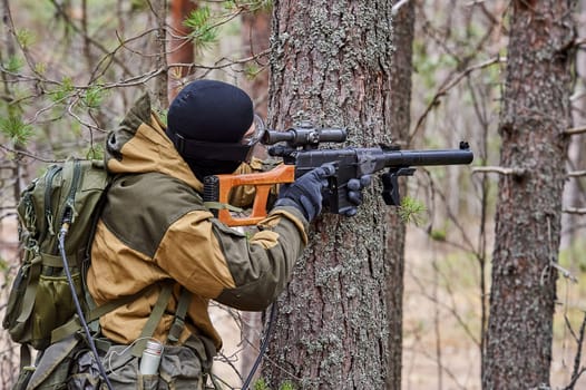 a man in the forest shoots from a machine gun. High quality photo