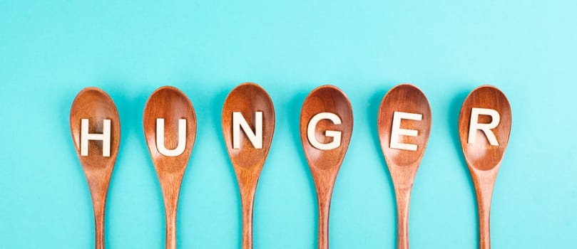 Hungry is standing in german language on the wooden spoons, food shortage and starving because of the war and inflation, political issue