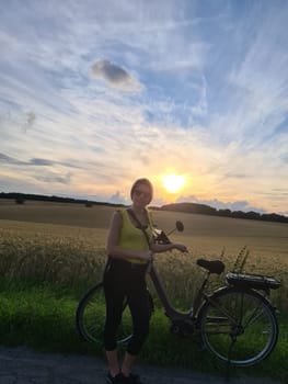 Young woman riding bicycle in summer city park outdoors. Active people. Hipster girl relax and rider bike. Cycling to work at summer day. Bicycle and ecology lifestyle concept