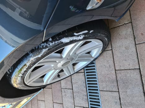HEILIGENHAUS, NRW, GERMANY - JUNE 01, 2020:.Close-up of aluminum rim of luxury car wheel. A Chrysler Crossfire tire and rim with a stone with Crossfire Roaster stone. Detail background