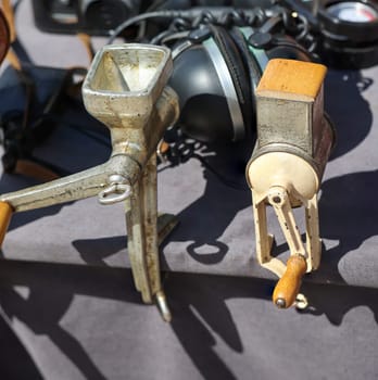 Two old meat grinders, meat grinder attached to a table.