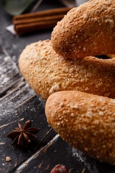 Pastries. Sweet buns on dark wooden table with an anise star and cinnamon sticks around them. Rustic and christmas concept. Selective focus. Blurred background. Banner.