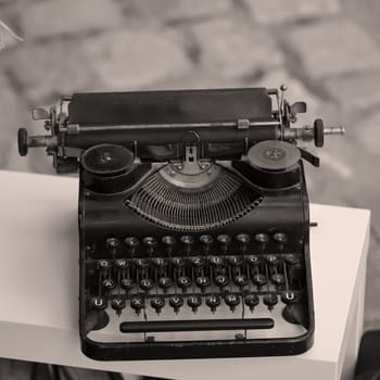 On an outdoor table stands an old nostalgic typewriter.