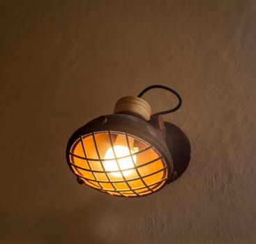 A spotlight-like lamp attached to a house wall.