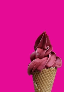 A waffle ice cream cone filled with a delicious freshly made raspberry soft serve ice cream.