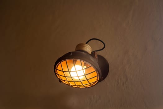 A spotlight-like lamp attached to a house wall.