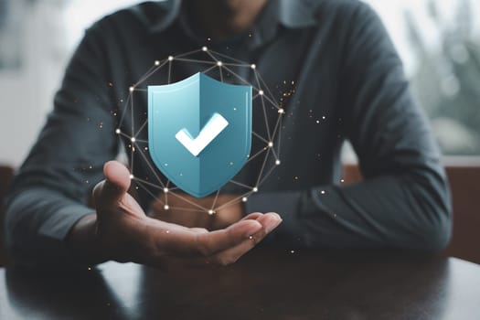 Businessman holding 3D digital shield protection with tick check mark on hand, Man sitting on desk hold network security data blue virus shield protect icon, Secure access system, Financial warranty