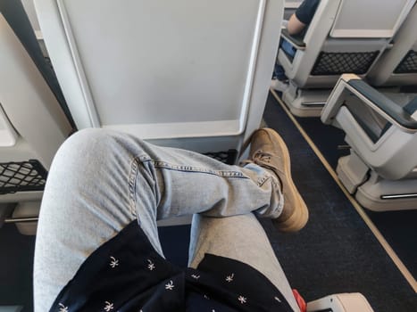 Young traveler sitting cross-legged in a train carriage. Point of view shot