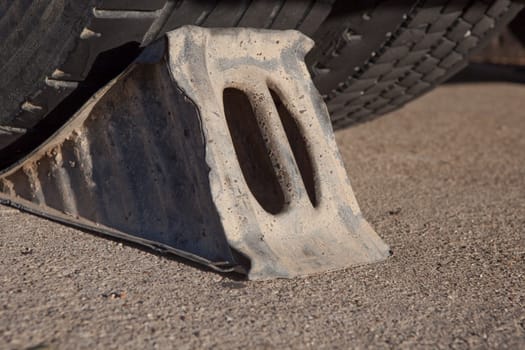 Full metal wheel chock under trailer. Ground view