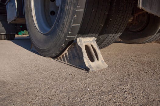 Full metal wheel chock under trailer. Ground view