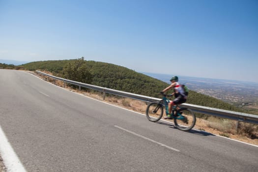 Senior cyclist speeding down the CC-139 winding road. Low motion shot