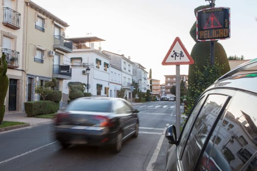 Vehicule crossing close to radar speed sign pole. Low motion shot