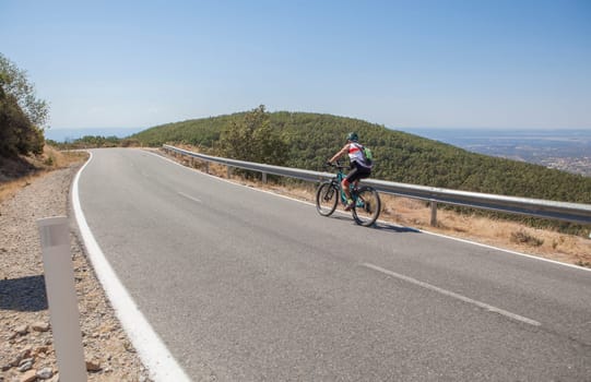 Senior cyclist speeding down the CC-139 winding road. Low motion shot
