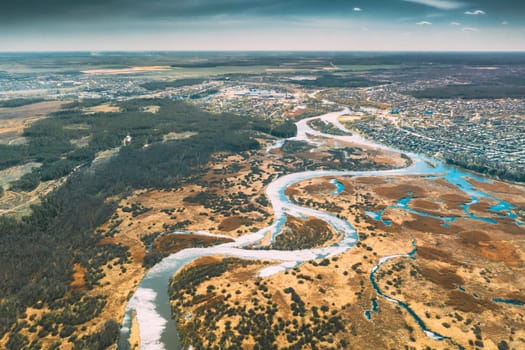 Belarus, Europe. Aerial View Curved River And Small Town In Early Spring Landscape. River bends Curves and dry grass landscape. Top View Of Beautiful European Nature From High Attitude. Drone View. Bird's Eye View.