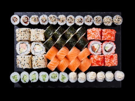 Top view sushi set. Philadelphia roll, california, unagi, black dragon with fresh ingredients on black background. Sushi menu. Japanese food.