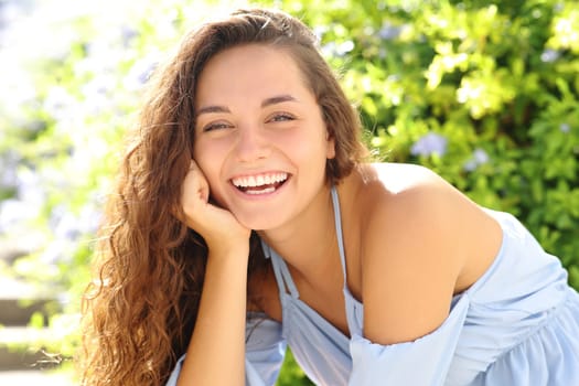 Portrait of a happy woman smiling at camera in a garden