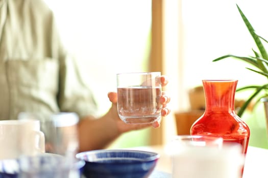 Close up portrait of a woman hand holding water glass in a restaurant