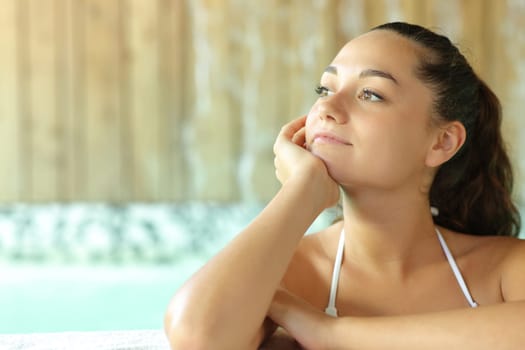 Pensive woman looking away in spa pool
