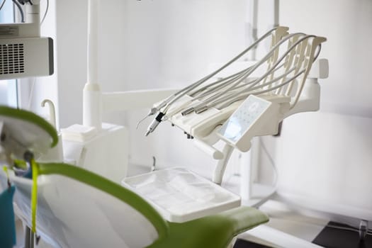 Special equipment for dentist. Equipment and dental instruments in bright modern dentist's office. Variety of medical instruments are arranged on side of dental chair. Selective focus.