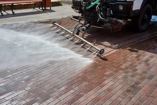 A special machine washes city paths and roads with water. High quality photo