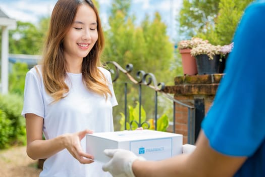Sick Asian young woman receive medicine first aid pharmacy box from hospital delivery service, happy female receiving patient medicine drug from delivery man, healthcare medicine online concept