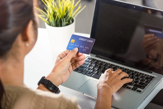 Online shopping. Woman hands holding credit card and using laptop with product purchase at home, female register via credit cards on computer to make electronic payment security online