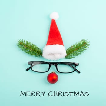 Face of a reindeer with a red bauble nose, fir antlers, a santa claus hat and eyeglasses, merry christmas greeting card