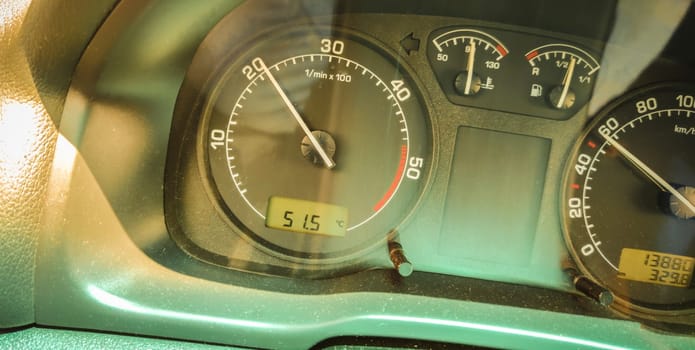 Car thermometer displays more than 50 degrees celsius. Driving concept with high outside temperatures