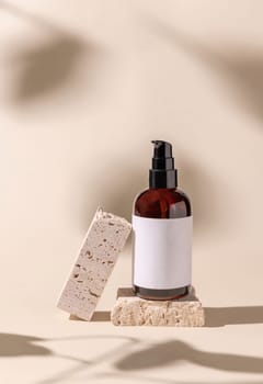 Brown Glass cosmetic one pump bottle on travertine stone on light beige, hard shadows, close up, label mockup. Skincare beauty product, lotion or essence. Natural cosmetics.