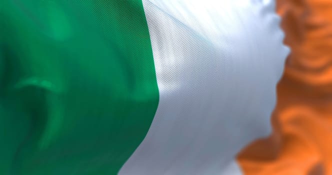 Close-up view of the irish national flag waving in the wind. Ireland is an island in the North Atlantic Ocean, in north-western Europe. Fabric textured background. Selective focus