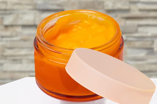 Closeup of an cosmetic jar of concealer cream, makeup foundation, moisturising cream for the face on table or other beauty make-up product over stone wall. Cosmetic label.