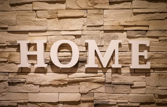 On a stone wall is attached lettering "HOME"". Stone texture."